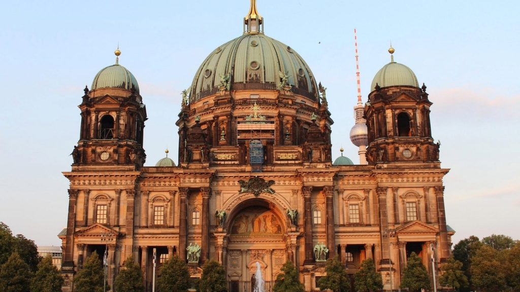 The magnificent Berlin Cathedral with its copper dome illuminated by sunset light.