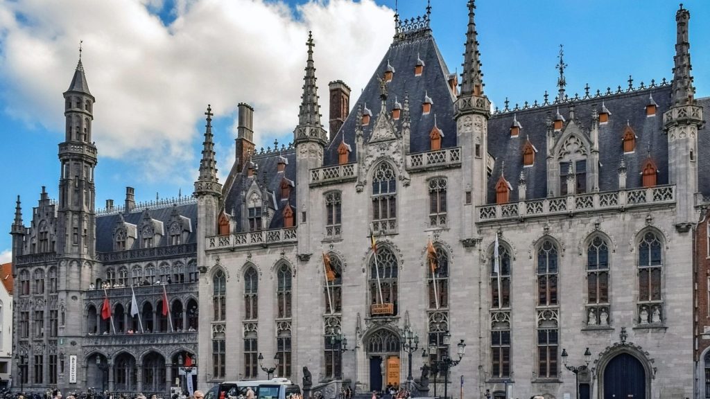 The Provincial Court building in Bruges showcasing exquisite Gothic Revival architecture with its ornate spires and façade, a popular stop on student trips to the city.