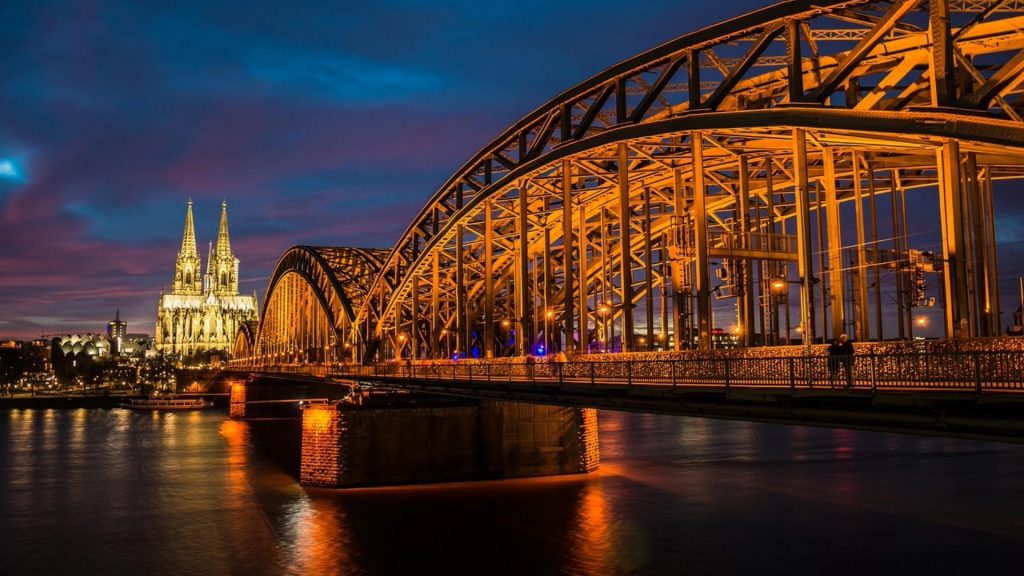 Hohenzollern Bridge lit golden at twilight—essential viewpoint for Cologne student tours.
