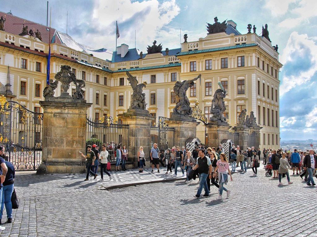 Visitors outside Prague Castle with its ornate baroque entrance.
