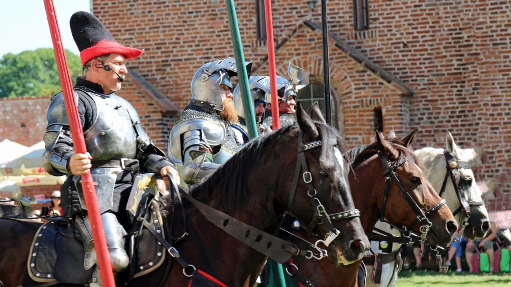 Armored knights on horseback during a castle reenactment.